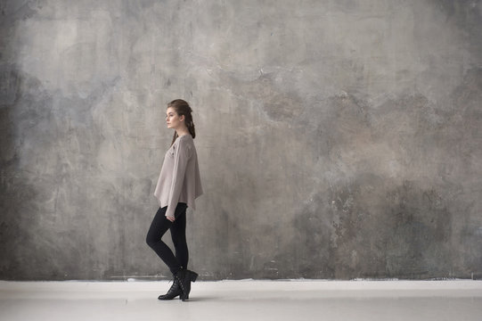Woman against concrete wall