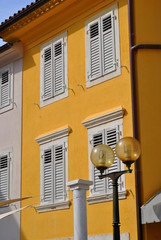 Żółty dom z okiennicami - obrazy, fototapety, plakaty