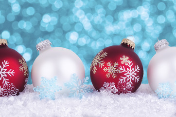 Christmas tree decorations on snowflakes. Bokeh lights  in background.