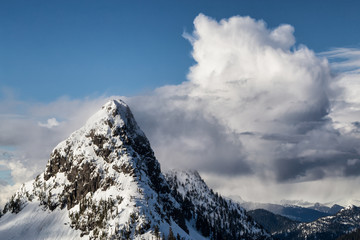 Aerial landscape view of the snow and cloud covered mountain range North of Vancouver, British Columbia, Canada.