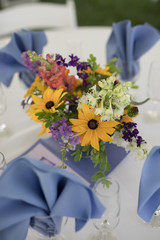 Wildflower Wedding Centerpieces with Black Eyed Susans, Snapdragons, and Delphinium on a Reception Table with White Tablecloth