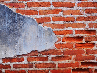 Old Broken grainy texture red brick tile wall background with part of blue grey weathered concrete on the left