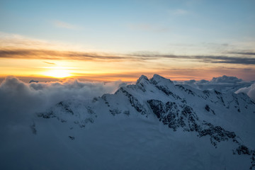 Fototapeta na wymiar Dreamy aerial landscape view of the beautiful snow covered mountains during a cloudy sunset. Picture taken of Tentalus Range near Squamish, British Columbia, Canada.