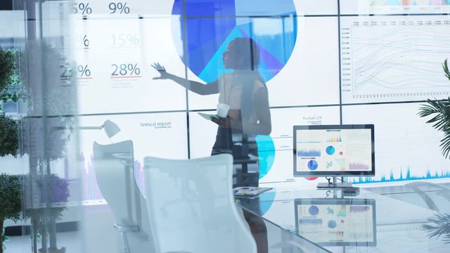  Businesswoman alone in meeting room rehearsing for business presentation