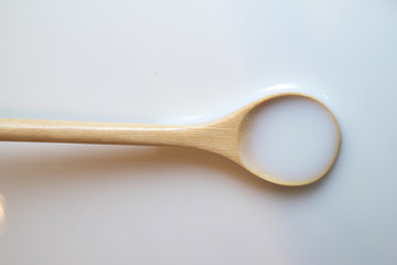 Sour cream in wooden spoon, milk in wooden spoon, yogurt in wooden spoon