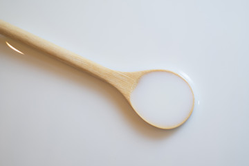 Sour cream in wooden spoon, milk in wooden spoon, yogurt in wooden spoon