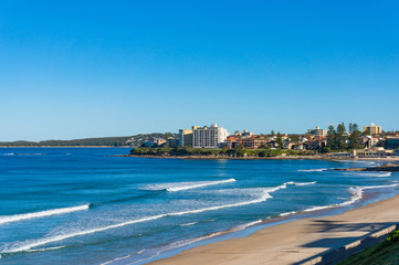 Ocean coastline with sand beach and waterfront property on the background