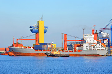 Tugboat assisting container cargo ship