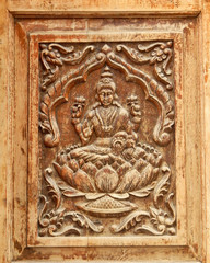 Wooden carving of Hindu Goddess Lakshmi on door of a temple
