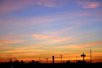 Silhouette of the electrical Pole and crane tower in Sunrise sky.