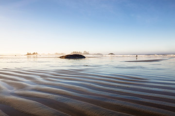Beautiful view of the sandy beach on Pacific Ocean. Picture taken in Chesterman, Tofino, Vancouver Island, British Columbia, Canada, during a sunny winter morning sunrise.