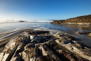 Long exposure landscape picture of a rocky beach on Pacific Ocean Coast. Picture taken at Chesterman, Tofino, Vancouver Island, British Columbia, Canada, during a winter morning.