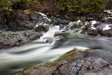 Nature view on the river flowing in between the rocks during winter. Picture taken near Tofino, Vancouver Island, British Columbia, Canada.