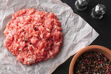 Parchment paper with fresh minced meat on table