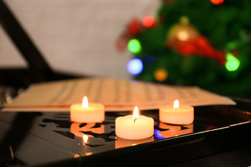 Candles on piano, closeup. Christmas music concept