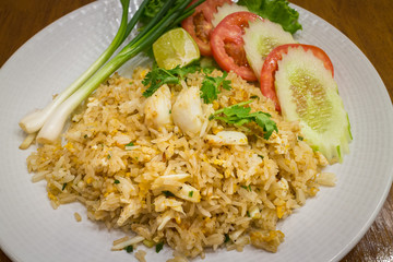 Healthy fried rice with crab in a white dish on wood table background for ready to serve.