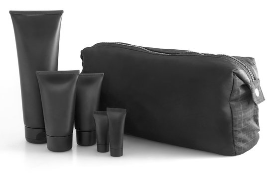 Black traveling cosmetic bag with toiletries in the front, isolated on white