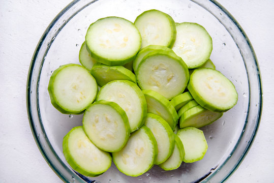 Green zucchini sliced in lobules in a glass plate 