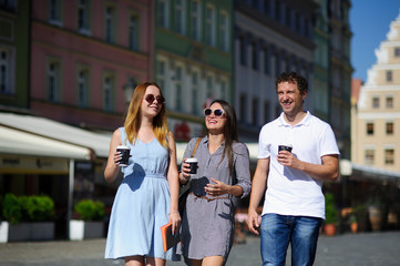 Fototapeta premium Group of young tourists stroll through the streets of an ancient city.