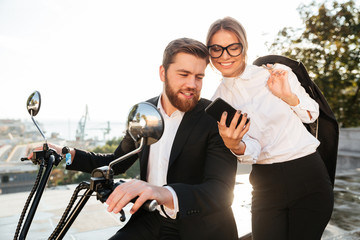 Happy business woman standing near bearded man in suit