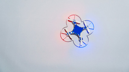 mini quadcopter with blue and red lights on the table