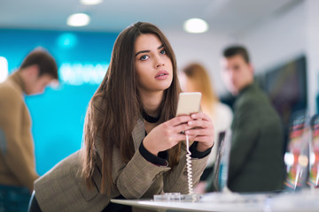 Attractive woman using on smart phone in store.