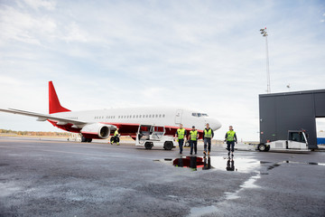 Ground Staff Walking Together On Wet Runway