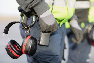Midsection Of Worker With Ear Protectors Attached To Trouser