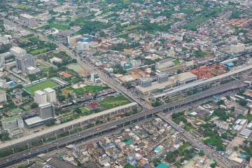 Aerial view of Bangkok, Thailand with building, road and highway in big city. View from airplane's window. Soft focus.