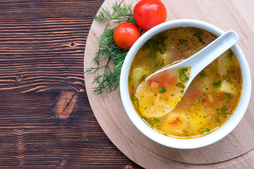 White soup noodles with tomatoes. Potatoes, dill, spices. On a wooden Board.