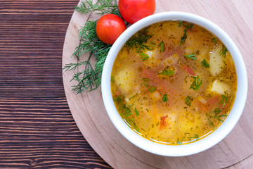 White soup noodles with tomatoes. Potatoes, dill, spices. On a wooden Board.