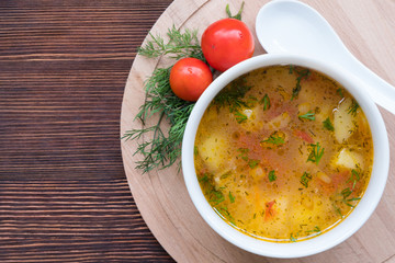 White soup noodles with tomatoes. Potatoes, dill, spices. On a wooden Board.