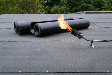 Heating and melting bitumen roofing felt Flat roof installation © htpix