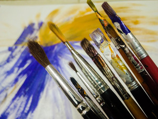 Obraz premium old paint brushes with paint on them 