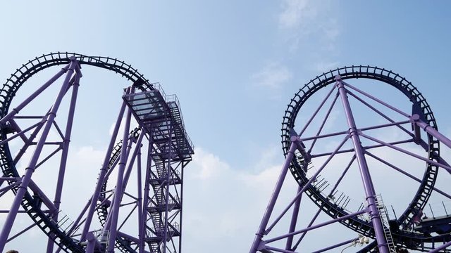 roller coaster, a trolley with people riding on the loops of a roller coaster 4k.