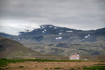 Obraz premium Scenic view of typical icelandic church in front of a snowy mountains.
