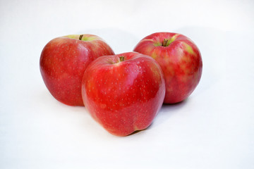 Three red ripe apples on white background.