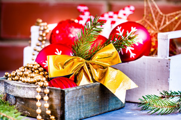 Christmas toys in a wooden boxes on a brick wall background.
