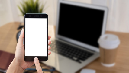 Asian woman hand holding smart phone on background workplace table.