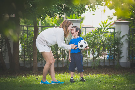 Asian mother and son Playing Soccer