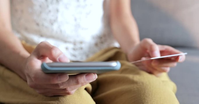 Woman using cellphone for online shopping at home