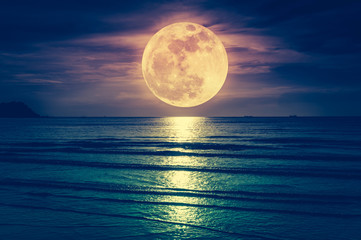 Super maan. Kleurrijke hemel met wolk en heldere volle maan over zeegezicht.