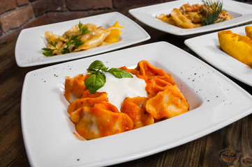 Set of different dumplings and ravioli on a wooden table