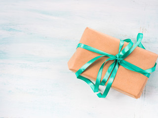 Gift box with green ribbon on pastel spring background. Copy space top view father's mother woman day Easter special occasion present