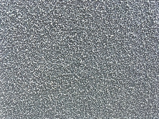 Background of scattered gray fine gravel. Texture of a stone surface, closeup