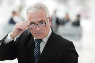 closeup of a senior businessman adjusting his glasses