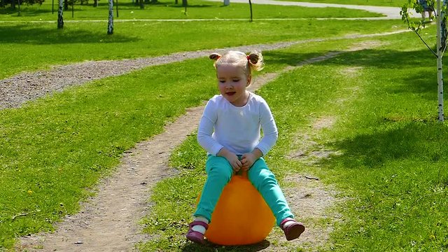 Little girl is jumping on the ball