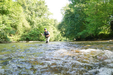 Fly fisherman fishing in French river