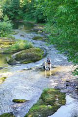 Obraz premium Aerial view of man with kid fly-fishing in river