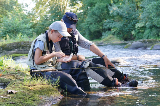 Dad helping son to choose flies for fishing line